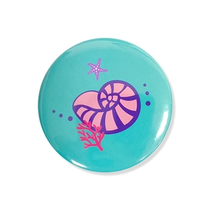 Detail of mermaid theme badge with seashell and coral illustration on blue background
