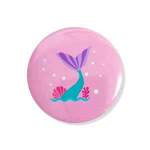 Close-up of glossy pink mermaid theme badge with seashell and coral illustration