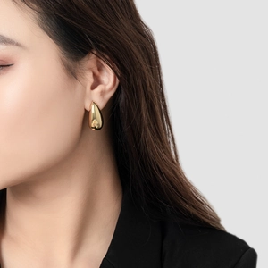 Minimalist 18K gold plated teardrop earrings with high-polish finish on a female model