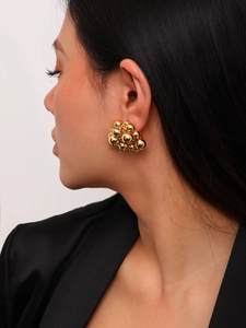 Close-up of elegant gold clustered metal sphere earrings on a female model
