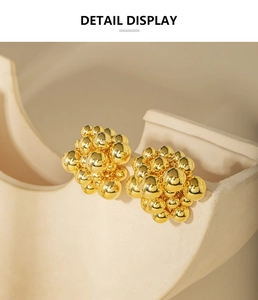 Detail view of gold cluster ball earrings with polished metallic sphere finish