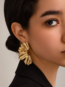 Close-up of elegant 18K gold plated pleated fan-shaped earrings worn by a model