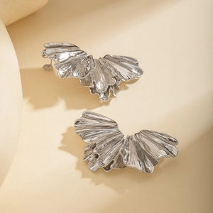 Detail of silver metallic earrings with pleated fan-shaped texture and flowing luster