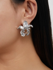 Close-up of silver-toned irregular flower earrings on a model showing refined textures