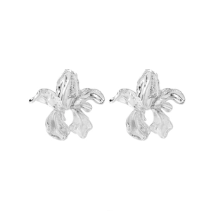 Macro shot of silver orchid flower stud earrings with fine radial petal texture