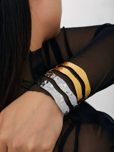 Detail of 18K gold and silver open bangles with unique hammered texture on model