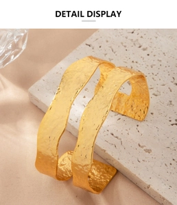 Macro shot of gold textured open cuff bracelet with hammered surface detail display