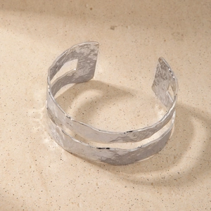 Macro shot of double-layered silver textured metal open bangle with hammered surface