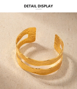 Detailed macro view of 18K gold hammered texture and hollow design on a wide cuff bracelet