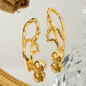 Détail de boucles d'oreilles ondulées en or 18 carats avec pendentif boule sur miroir