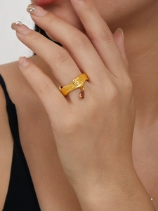 Detail eines 18K vergoldeten strukturierten Rings mit einem tropfenförmigen roten Edelstein
