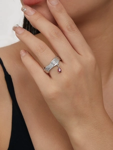 Nahaufnahme eines silbernen Rings mit rotem Tropfenanhänger aus Zirkonia am Modell