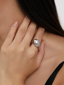 Bague goutte argentée polie montrant un design sculptural minimaliste à la main