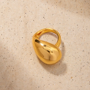 Gros plan d'une bague goutte en laiton plaqué or 18K avec finition miroir polie