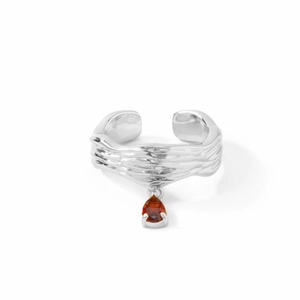 Detail eines silbernen strukturierten Rings mit orange-rotem Tropfen-Edelsteinanhänger