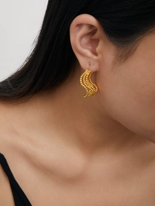 Detailed close-up of 18K gold plated multi-layer beaded hoop earrings on a model's ear