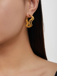 Detail of 18K gold plated multi-layer wavy beaded earrings on female model