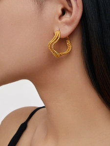 Detail of twisted 18K gold plated beaded earrings showing vintage wave texture on ear