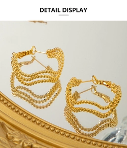 Detail view of 18K gold plated triple-layer wavy beaded earrings with metallic luster