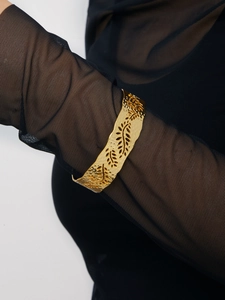 Detail of 18K gold plated wide leaf cuff bracelet with hollow design and hammered texture