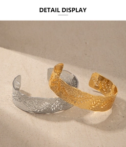 Detail of hollow leaf bangles in gold and silver finish with hammered metal texture