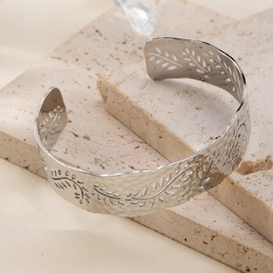 Detailed view of silver hammered texture open cuff bracelet with leaf cutout design