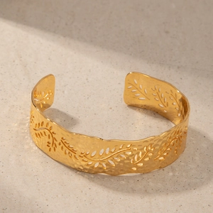 Detail of 18K gold plated cuff with hammered texture and hollow leaf vine pattern
