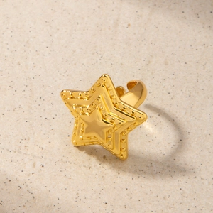 Vue détaillée d'une bague étoile dorée 18 carats avec des bords en relief et design