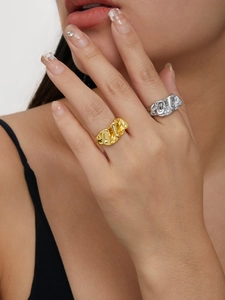 Detail shot of irregular lava texture rings in gold and silver finish on model