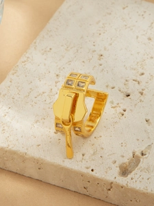 Nahaufnahme eines goldenen Rings im Reißverschluss-Design mit Zirkonia-Steinen