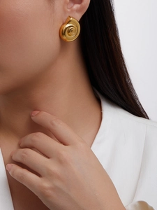Close-up of 18K gold-plated conch shell earring with spiral texture on model