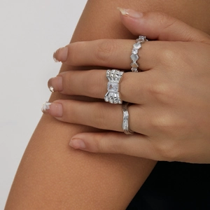 Set di 3 anelli in argento con fiocco e zirconi, fedi con texture ondulata sulla mano