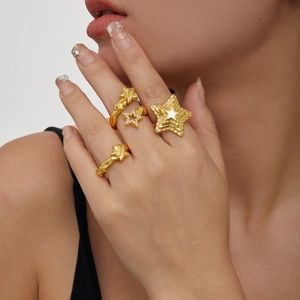 Ensemble de bagues étoiles dorées 18 carats avec zircones et textures sur la main du modèle