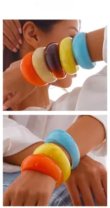 Gros plan de joncs épais en résine colorée empilés sur le poignet d'un mannequin