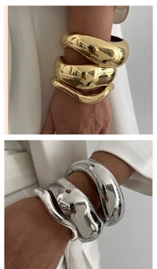 Macro shot of chunky irregular metal bangles in polished gold and silver finishes