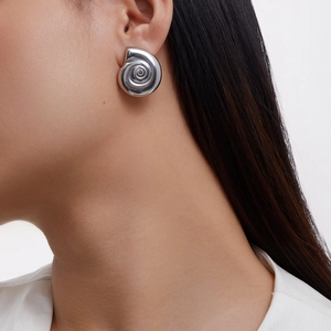Minimalist spiral snail drop earrings in polished silver-tone finish on a model