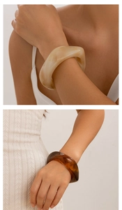 Close-up of retro irregular resin bangles in cream marble and dark amber tortoiseshell
