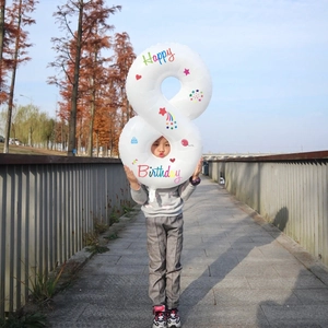 Detail of white number 8 foil balloon with colorful Happy Birthday print and stars