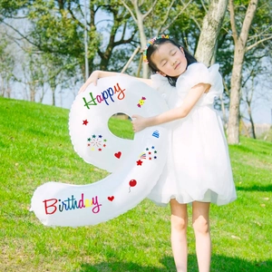 Little girl holding a 40-inch white number 9 balloon with colorful Happy Birthday prints
