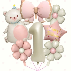 Detailed close-up of cream bear and pink bow foil balloons for 1st birthday party setup