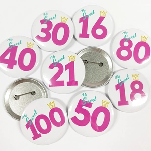 Gros plan de badges d'anniversaire en fer-blanc colorés de 16 à 100 ans pour fête