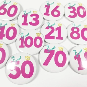 Vue à plat de badges d'anniversaire roses avec couronnes dorées pour célébrations