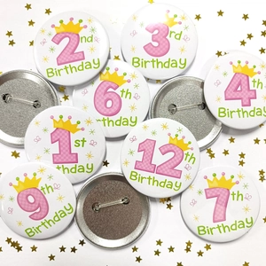 Détails de badges d'anniversaire à carreaux roses avec couronnes sur fond blanc
