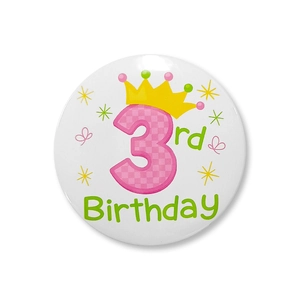 Détail macro du badge 3ème anniversaire avec chiffre 3 à carreaux roses et couronne