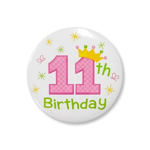 Détail du badge d'anniversaire 11 ans en fer-blanc de 58 mm avec numéro rose et couronne
