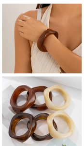 Macro detail of irregular wavy resin bangle in tortoise shell and cream white finish