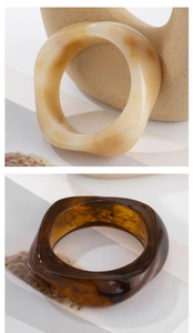 Close-up of irregular resin bangles in cream marble and dark amber tortoiseshell textures