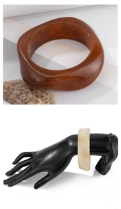 Detail view of tortoiseshell resin bangles with amber and marble texture effects