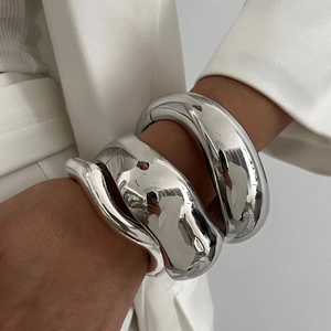 Three-piece set of silver chunky geometric bangles with a polished metallic finish