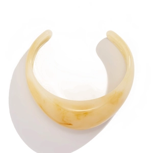 Bracelet jonc ouvert minimaliste en résine avec texture marbre ambre sur fond blanc